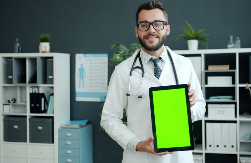Doctor holding a tablet with a green screen.