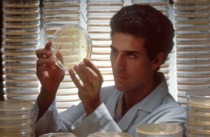 a man in a lab coat holding up a plate